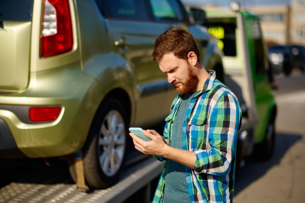 Man On HIs Phone and A Towed Car Behind